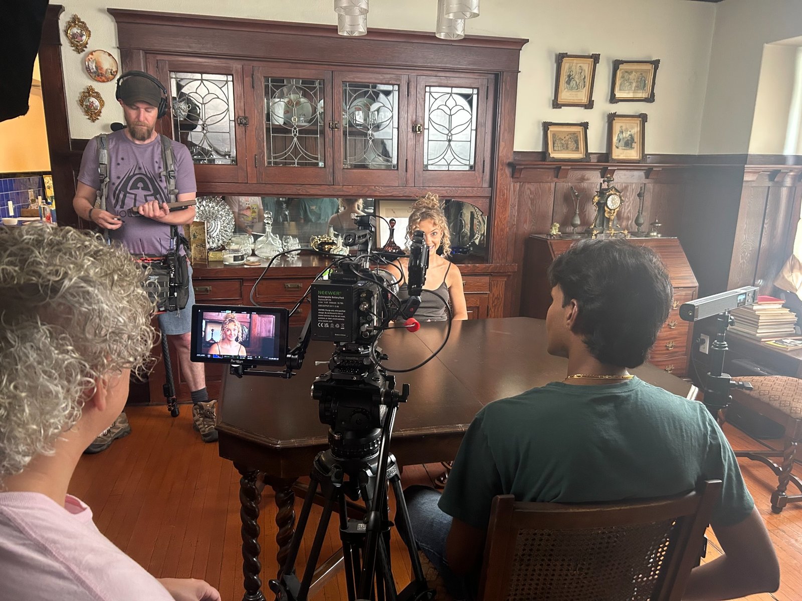 Performers and crew working together around a camera on an indoor film set